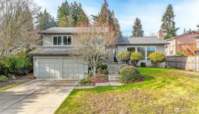 This 4 bedroom home has a very long driveway.  There is a sidewalk on both sides of the street and the central mailbox kiosk for U.S. Postal service is located on the far corner, to the right of this front lawn.