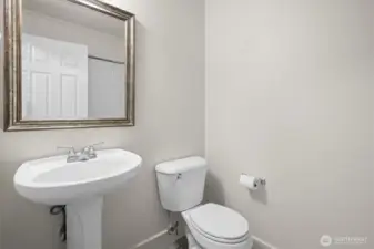Half bath with pedestal sink conveniently located on the first floor