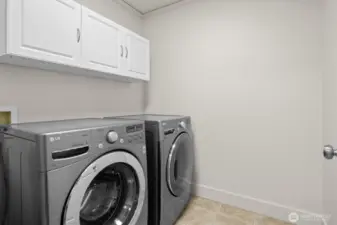 Spacious laundry room with built-in cupboards for storage
