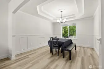 Formal dining room with ornate tray ceiling and chair-rail molding