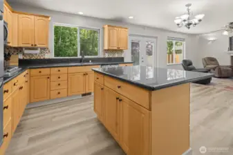 Updated kitchen featuring an oversized island with seating, granite countertops, gas cooktop and full-size double wall ovens. Stainless steel kitchen appliances all stay.