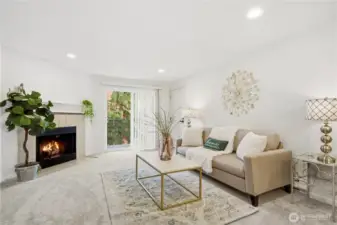 Bright and inviting living room with fresh paint, updated flooring, and a cozy wood-burning fireplace.