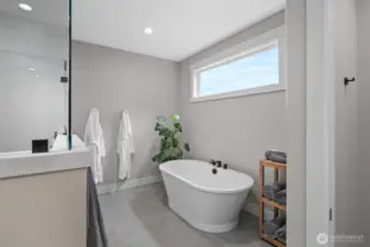 Deep stand-alone tub, ready for relaxing. This tub offers a comfortable and inviting space for unwinding after a long day. Its design prioritizes relaxation, making it an ideal spot for stress relief and rejuvenation.