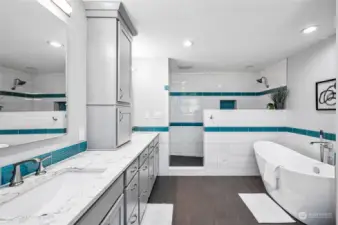 The owner’s bathroom is equally impressive, with an appliance cabinet, backlit mirrors, and luxurious quartz counters