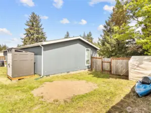 At the back of the home is a fence and gate separating the garden area.