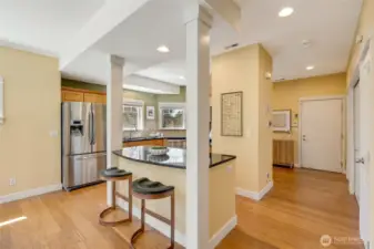 Open walkway to entry and kitchen, highlighting the fluid floor plan and easy navigation throughout the home.