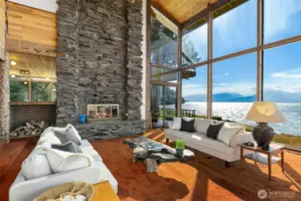 The floor to ceiling flagstone fireplace is a great match to the soaring window wall in the livingroom area.
