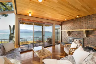 Another view of the family room together with a fireplace and insert.  The sculpture you see outside on the deck is your very own resident eagle!  Carved on site from a tree that the deck was built around!