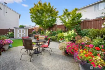 Private backyard retreat surrounded by colorful flower beds.
