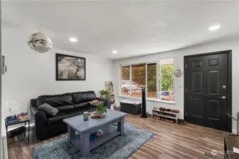 Living room with full window adjacent home entrance