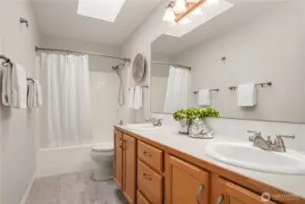 The main bathroom features new LVP flooring, a skylight and dual sinks as well as fantastic storage.