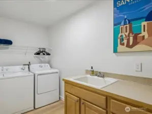 Extra large laundry room with sink and large linen closet.