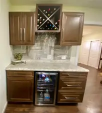 Amazing beverage refrigerator, wine rack, and abundant storage complete with a space to prepare the beverage of your choice!