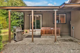 Covered patio with very clean hot tub.