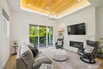 Look up and let the warmth surround you—tray ceilings with natural wood inlay and ambient lighting add architectural depth and a touch of modern luxury to this inviting living space. It’s a design detail that quietly elevates every moment, from cozy mornings to evening gatherings.