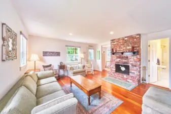 Cozy and full of soul—original fir floors and a warm brick fireplace create the perfect place to unwind after a beach day.