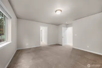 Primary bedroom looking back towards bath and walk in closet