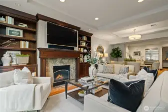 Open living room with gas fireplace and custom built-ins.