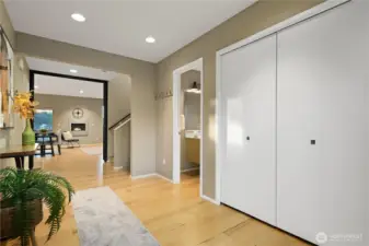 This second photo of the entryway shows the warm wood floor and spacious nature of this landing. There is a double closet here for coats and additional storage and the 1/2 bath on the main is shown just to the right of the hall.