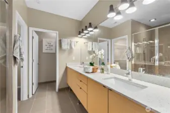 This bath features a double vanity sink and a large, handsomely tiled shower. The water closet is enclosed for additional privacy.