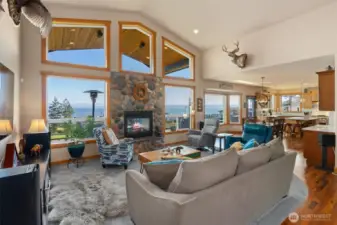 Living room with dual-sided gas fireplace opens to dining and kitchen