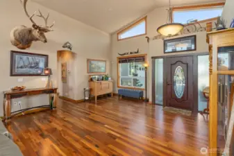 Large entry with Tigerwood floors. Hallway leads to half bath and guest bedrooms