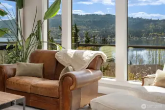 Living room with vaulted ceilings, window wall & gas fireplace. New hardwood floors, doors & trim on the main level & Milgard Windows throughout.