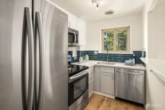 Kitchen with lookout window and SS appliances.