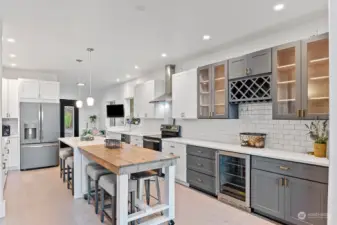 The beautiful gray cabinets are such a nice touch against the white subway tile and quartz counters. A built in beverage fridge and wine bottle rack will make serving guest's favorite beverages a breeze. A walk-in pantry, not shown, is at the end of the kitchen to the left.