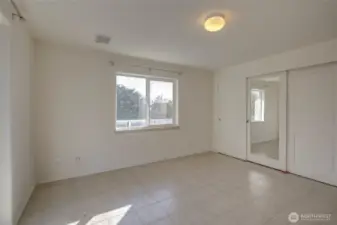 Lower unit primary bedroom with walk out. Notice the whole left wall is storage. This bedroom connects to the lower level primary bath.