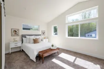 Primary bedroom is large with vaulted ceilings.