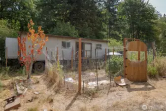 single, dry container with power and a "bedroom"; fenced garden area.