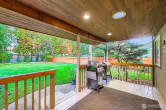 A fantastic back deck overlooking a large flat yard, complete with an irrigation system.