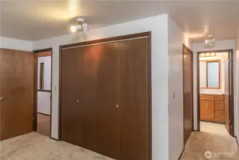 View of the primary bedroom, with a full bath on the right, and dual closets.