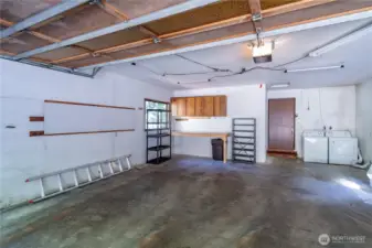 The oversized two-car garage has a small work bench, some cabinets, and a washer/dryer hook up.