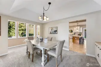 Stylish formal dining room with vaulted tray ceiling, ideally located off the kitchen and with backyard access.