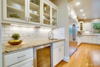 The butler’s pantry dazzles with glass-front cabinetry, a wine refrigerator, and a prep sink, creating the ideal spot for a coffee station, stylish bar, or extra prep space for festive holiday gatherings.