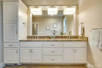 Double sinks, crown molding on the cabinets, and elevated trim around the mirror give it a hotel-like feel.