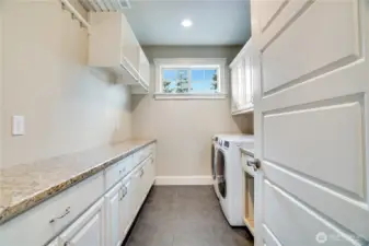 The upstairs laundry room offers plenty of extra storage, handy drying racks, a utility sink, and slate floors that make cleaning a breeze. Right outside, a linen closet keeps towels, sheets, pillows, and blankets neatly organized.