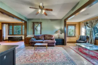 Large family room with original wood trim, sun room and dining room.