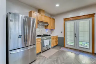 Kitchen with gas range, herring bone flooring and newer cabinets and counter tops.