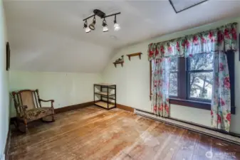 Large upstairs bedroom with fir floors is light and bright.