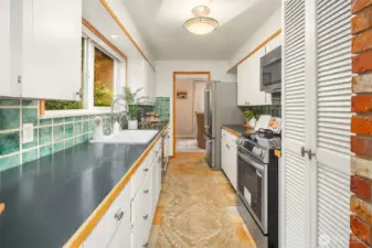 Galley kitchen with brand new range and updated hardware.