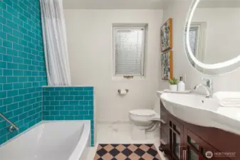 Primary bathroom with shower/tub combo and radiant heat tile flooring.