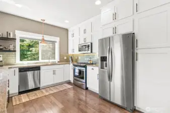 The cabinets feature under cabinet lighting, enhancing both functionality & ambiance.