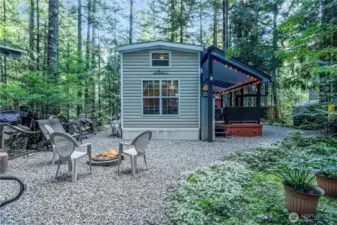 Rear yard fire pit seating area surrounded by trees.