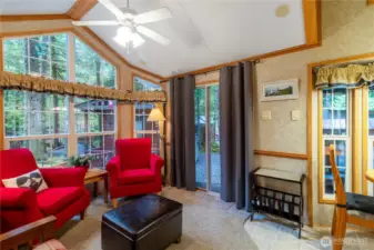 Bright living room w/ vaulted ceiling & large picture windows.