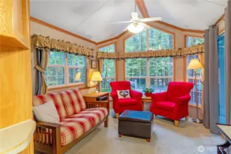 Living room sitting area w/ forest views.