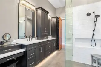 Designed with sophistication, this primary ensuite spa features heated floors that offer warmth underfoot and under-cabinet lighting that casts a gentle, welcoming glow and a large, zero barrier shower. Large walk-in California custom closet not shown.