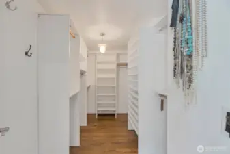 Primary bedroom walk in closet features custom designed cabinetry to really make the best use of every inch of space!